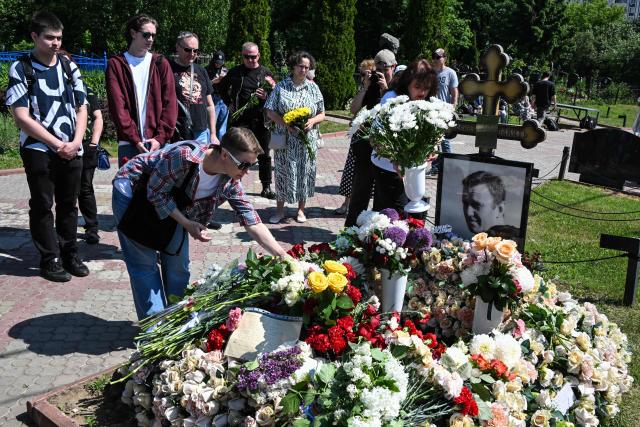 People lay flowers at the grave of the late Russian opposition leader Alexei Navalny to mark his 50th birthday at the Borisovo cemetery in Moscow on June 4, 2026. (Photo by Igor IVANKO / AFP) / NAVALNY HAS BEEN DECLARED "EXTREMIST" BY RUSSIAN AUTHORITIES. IN RUSSIA, ANYBODY WHO MENTIONS NAVALNY OR HIS ANTI-CORRUPTION FOUNDATION WITHOUT STATING THAT THEY HAVE BEEN DECLARED "EXTREMIST" IS SUBJECT TO FINES OR UP TO FOUR YEARS IN PRISON FOR REPEATED OFFENCES.