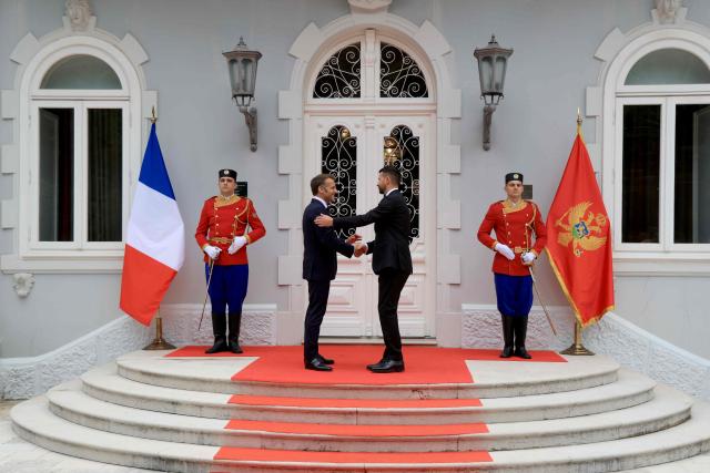 Montenegro's President Jakov Milatovic shakes hand with France's President Emmanuel Macron during a welcome ceremony ahead of their meeting at the Blue Palace as part of Macron's first official visit to Montenegro ahead of the EU-Western Balkans Summit, in Cetinje on June 4, 2026. (Photo by Ludovic MARIN / AFP)