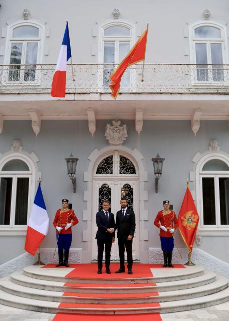 Montenegro's President Jakov Milatovic shakes hand with France's President Emmanuel Macron during a welcome ceremony ahead of their meeting at the Blue Palace as part of Macron's first official visit to Montenegro ahead of the EU-Western Balkans Summit, in Cetinje on June 4, 2026. (Photo by Ludovic MARIN / AFP)