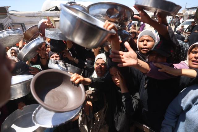 Displaced Palestinians, including women and children, gather to receive hot meals distributed by a charity kitchen in the Khan Yunis refugee camp in the southern Gaza Strip, on June 4, 2026. The food distribution comes amid ongoing shortages of food supplies caused by Israeli attacks and restrictions on aid entering the Gaza Strip. (Photo by Bashar Taleb / AFP)