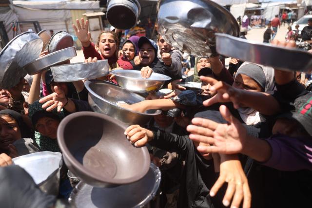 Displaced Palestinians, including women and children, gather to receive hot meals distributed by a charity kitchen in the Khan Yunis refugee camp in the southern Gaza Strip, on June 4, 2026. The food distribution comes amid ongoing shortages of food supplies caused by Israeli attacks and restrictions on aid entering the Gaza Strip. (Photo by Bashar Taleb / AFP)