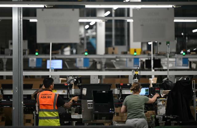 Employees work on the packing line inside Amazon's LCY3 Fulfillment Centre in Dartford, east of London, on June 4, 2026, on the second day of company's 'Delivering the Future EMEA ‘26' event. (Photo by JUSTIN TALLIS / AFP)