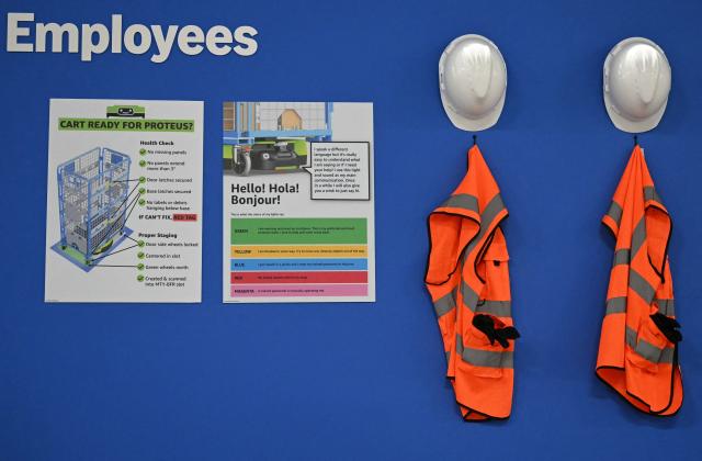 A signs asks Amazon employees to check if a cart is 'ready' to be moved by a next-generation Proteus robot, during the second day of 'Delivering the Future EMEA ‘26', at Amazon’s LCY3 Fulfillment Centre in Dartford, east of London, on June 4, 2026. (Photo by JUSTIN TALLIS / AFP)