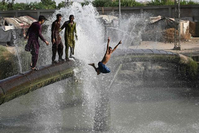 Youth cool off on a leaking water pipeline on a hot summer day in Pakistan's Hyderabad city on June 4, 2026. (Photo by Rizwan TABASSUM / AFP)