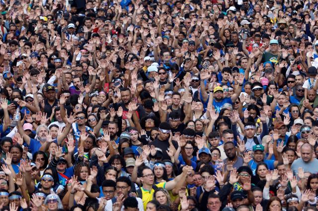 People raise their hands as they take part in the "March for Jesus", an event that gathers a wide range of evangelical congregations, in Sao Paulo, Brazil on June 4, 2026. (Photo by Miguel SCHINCARIOL / AFP)