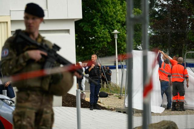 French soldiers and police officers stand guard next to the place a young man has been shot dead in Nantes, western France, on June 4, 2026. It is the fourth such death in the city since late April, according to police sources. Police officers, after being called to the scene following reports of gunfire, discovered the body of the man in the La Bottiere neighborhood. (Photo by Loic VENANCE / AFP)