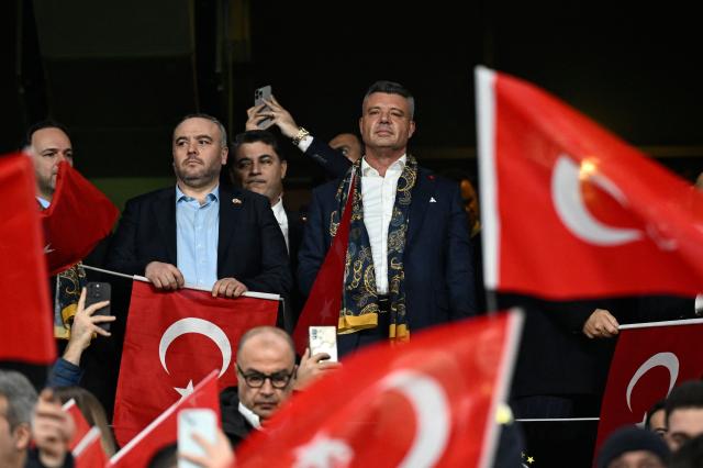 (FILES) Turkish-American businessman and president of Fenerbahce, Sadettin Saran (C) watches the Europa League first round day 7 football match between Fenerbahce and Aston Villa at Sukru Saracoglu Stadium in Istanbul on January 22, 2026. The outgoing president of Turkish football giants Fenerbahce was sentenced to two-and-a-half years in prison on June 4, 2026, for "inciting illegal gambling," state news agency Anadolu reported.  Turkish-American sports executive and businessman Sadettin Saran was accused of broadcasting advertisements for illegal betting sites on a video platform owned by his holding company. (Photo by Yasin AKGUL / AFP)