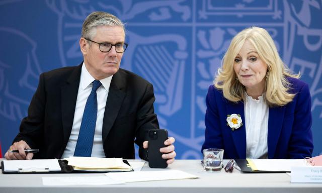 Britain's Prime Minister Keir Starmer (L) holds a mobile phone as he sits with Mayor of West Yorkshire, Tracy Brabin, during a meeting of Regional Mayors at the National STEM Learning Centre in York, northern England, on June 4, 2026. (Photo by James Glossop / POOL / AFP)