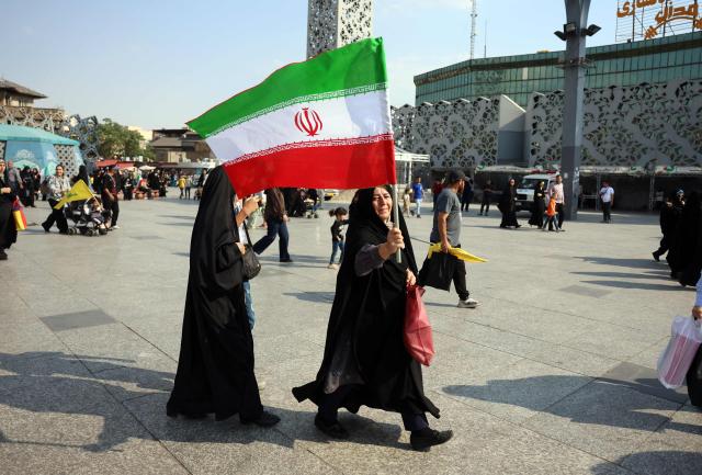 A woman waves Iran's national flag during a rally in support of the country's supreme leader Mojtaba Khamenei and celebrating the Eid al-Ghadir in Tehran on June 4, 2026. Eid al-Ghadir commemorates the events of Ghadir al-Khumm during which Shiites believe that the Prophet Mohammed appointed Ali ibn Abi Talib, his cousin and son-in-law who was among the first Muslims, as his successor. (Photo by AFP) / 