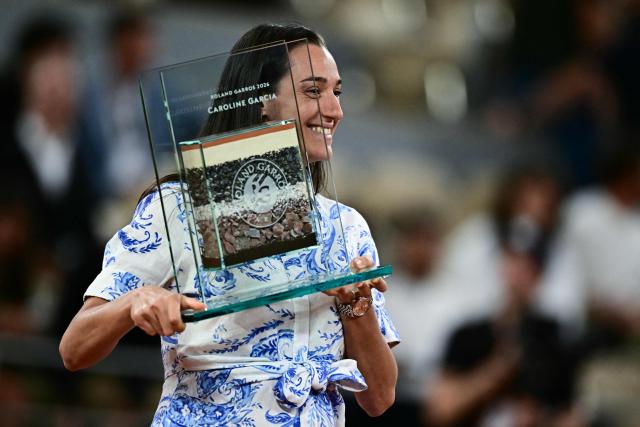 Former French tennis player Caroline Garcia holds a trophy during a ceremony in homage to her career on day 12 of the French Open tennis tournament on Court Philippe-Chatrier at the Roland-Garros Complex in Paris on June 4, 2026. (Photo by JULIEN DE ROSA / AFP)