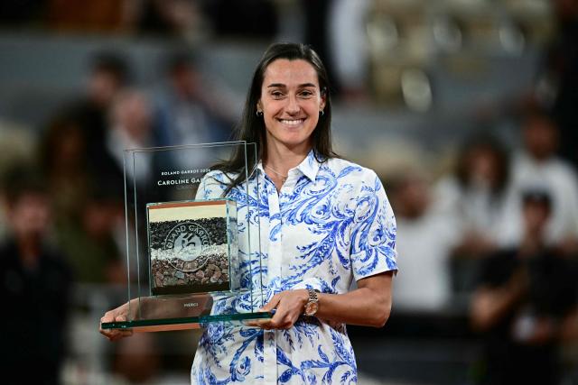 Former French tennis player Caroline Garcia holds a trophy during a ceremony in homage to her career on day 12 of the French Open tennis tournament on Court Philippe-Chatrier at the Roland-Garros Complex in Paris on June 4, 2026. (Photo by JULIEN DE ROSA / AFP)