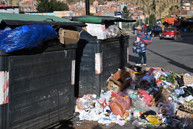 Accumulated garbage is seen in a street in La Paz on June 4, 2026, amid growing political tensions and supply shortages affecting different regions of the country. The accumulation of waste in the city reached critical levels between late May and early June, posing a serious public health and environmental risk. The disruption of garbage collection services has been attributed to road blockades and, mainly, to a shortage of diesel fuel for collection trucks. (Photo by Aizar RALDES / AFP)