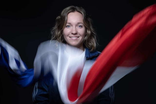 French biathlete and Olympic medalist Oceane Michelon, poses with a national flag during a photo session in Paris on June 4, 2026. (Photo by Joel Saget / AFP)