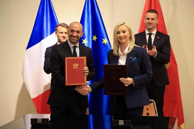 France's President Emmanuel Macron (L) and Montenegro's Prime Minister Milojko Spajic (R) watch as France's junior Minister in charge of Europe Benjamin Haddad (2nd L) and Montenegro's Minister of European Affairs Maida Gorcevic pose after signing a Memorandum of Understanding on the enlargement of the European Union as part of a signing ceremony covering transport infrastructure, energy and defence cooperation at the Montenegrin Ministry of Culture and Media during Macron's first official visit to Montenegro in Cetinje on June 4, 2026. (Photo by Ludovic MARIN / AFP)