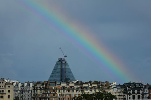 This photograph shows a rainbow over the Tour Triangle, designed by Swiss Architectural firm Herzog & de Meuron, from Court Philippe-Chatrier on day 12 of the French Open tennis tournament, in Paris on June 4, 2026. (Photo by Thomas SAMSON / AFP)