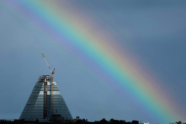 This photograph shows a rainbow over the Tour Triangle, designed by Swiss Architectural firm Herzog & de Meuron, from Court Philippe-Chatrier on day 12 of the French Open tennis tournament, in Paris on June 4, 2026. (Photo by Thomas SAMSON / AFP)