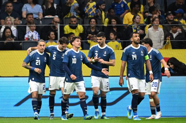 Greece's defender #21 Kostas Tsimikas (L) celebrates scoring his team's first goal with teammates during the friendly match between Sweden and Greece ahead of the 2026 FIFA World Cup football tournament, in Solna, near Stockholm, on June 4, 2026. (Photo by Jonathan Nackstrand / AFP)