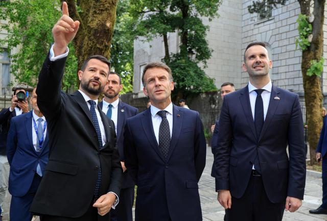France's President Emmanuel Macron (C) listens to Montenegro's President Jakov Milatovic (L) flanked by Montenegro's Prime Minister Milojko Spajic (R) during his first official visit to Montenegro ahead of the EU-Western Balkans Summit in Cetinje on June 4, 2026. (Photo by Ludovic MARIN / AFP)