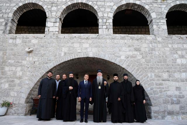 France's President Emmanuel Macron (C) poses for a family photo flanked by bishop of Montenegro Joanikije Micovic and members of the clergy during a visit of the Cetinje Monastery during his first official visit to Montenegro ahead of the EU-Western Balkans Summit in Cetinje on June 4, 2026. Founded in 1484, the monastery is one of Montenegro's most significant spiritual and cultural sites and serves as a major center of Serbian Orthodox Christianity in the country. (Photo by Ludovic MARIN / AFP)