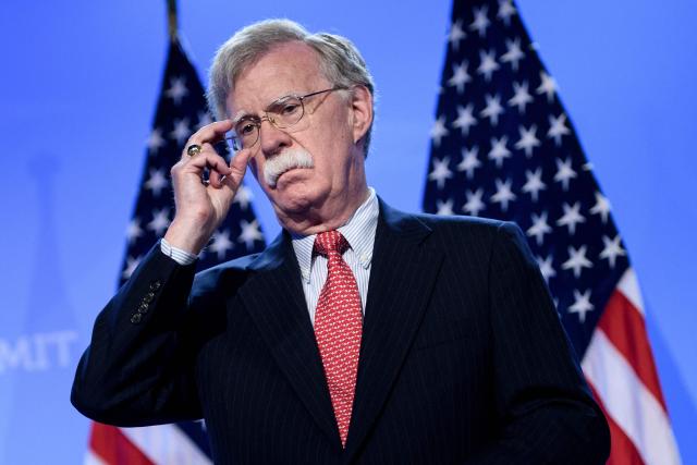 (FILES) US National Security Advisor John Bolton looks on as US President Donald Trump addresses a press conference on the second day of the North Atlantic Treaty Organization (NATO) summit in Brussels on July 12, 2018. Bolton, who served as Donald Trump's national security advisor before becoming an outspoken critic of the US president, plans to plead guilty to one count of retaining classified documents, US media reported on June 4, 2026. he 77-year-old veteran diplomat is expected to enter the guilty plea at a hearing in federal district court in Maryland on June 26, CNN and other outlets said. (Photo by Brendan Smialowski / AFP)