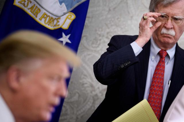 (FILES) National Security Advisor John R. Bolton listens while US President Donald Trump speaks to the press before a meeting with Hungary's Prime Minister Viktor Orban in the Oval Office of the White House on May 13, 2019, in Washington, DC. Bolton, who served as Donald Trump's national security advisor before becoming an outspoken critic of the US president, plans to plead guilty to one count of retaining classified documents, US media reported on June 4, 2026. he 77-year-old veteran diplomat is expected to enter the guilty plea at a hearing in federal district court in Maryland on June 26, CNN and other outlets said. (Photo by Brendan Smialowski / AFP)