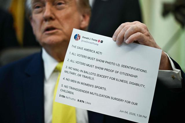 US President Donald Trump holds a printed copy of a post from his Truth Social account about "The Safeguard American Voter Eligibility Act" (also known as the "SAVE America Act") as he speaks in the Oval Office of the White House in Washington, DC on June 4, 2026. (Photo by Brendan SMIALOWSKI / AFP)