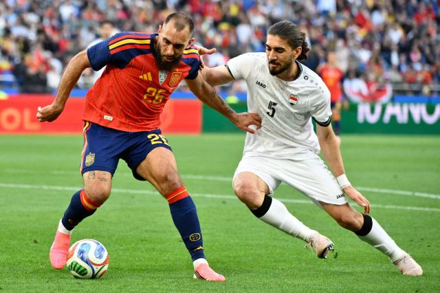 Spain's forward #26 Borja Iglesias and Iraq's defender #05 Akam Hashim Rahman fight for the ball during the international friendly football match between Spain and Iraq ahead of the 2026 FIFA World Cup football tournament, at the Riazor stadium in A Coruna, northern Spain, on June 4, 2026. (Photo by Ander Gillenea / AFP)