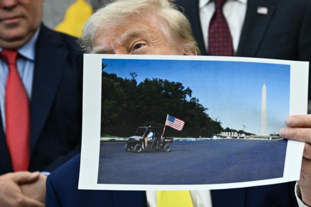 US President Donald Trump holds a picture of the newly resurfaced Reflecting Pool on the National Mall as he speaks in the Oval Office of the White House in Washington, DC on June 4, 2026. (Photo by Brendan SMIALOWSKI / AFP)