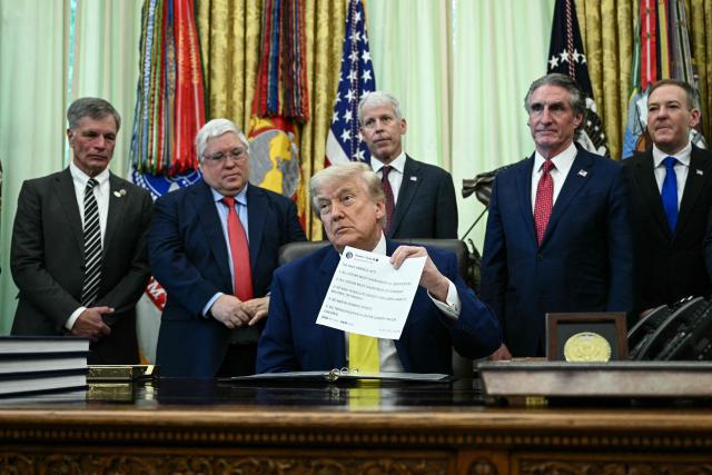 US President Donald Trump holds a printed copy of a post from his Truth Social account about "The Safeguard American Voter Eligibility Act" (also known as the "SAVE America Act") as he speaks in the Oval Office of the White House in Washington, DC on June 4, 2026. (Photo by Brendan SMIALOWSKI / AFP)