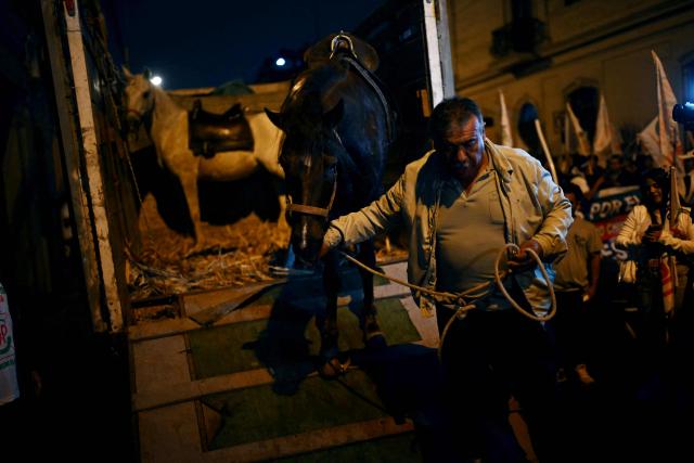 A man lowers a horse from a truck that Peru's presidential candidate for the Juntos por el Peru party, Roberto Sanchez, will use to arrive at his closing campaign rally in Lima on June 4, 2026. Right-wing candidate Keiko Fujimori and leftist Roberto Sanchez will face off in Peru's presidential runoff on June 7, 2026. (Photo by ERNESTO BENAVIDES / AFP)