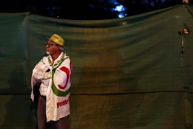 A supporter of Peru's presidential candidate for the Juntos por el Peru party, Roberto Sanchez, waits for the start of his closing campaign rally in Lima on June 4, 2026. Right-wing candidate Keiko Fujimori and leftist Roberto Sanchez will face off in Peru's presidential runoff on June 7, 2026. (Photo by Connie FRANCE / AFP)