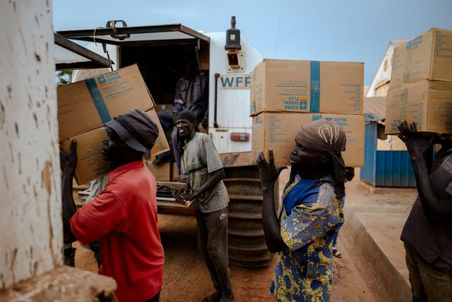 (FILES) Workers load food commodities onto World Food Programme (WFP) SHERPs at the WFP logistics base in Bentiu, Unity State, South Sudan, on November 3, 2025. The SHERP all-terrain vehicles are used by the UN agency to deliver food and humanitarian aid to flood-affected and hard-to-reach areas. The amphibious vehicles have become vital for overland delivery as global aid cuts strain relief operations in South Sudan. Hundreds of thousands displaced by conflict in South Sudan are increasingly forced to sell part of their rations to pay for basic needs at a time when the economy has almost entirely collapsed. One of the world's poorest countries, South Sudan has been mired in corruption and civil war for much of its existence since gaining independence in 2011. When US President Donald Trump ordered the shutdown of USAID last year, South Sudan lost a huge chunk of its humanitarian support at a time when nearly two-thirds of the population -- some 7.9 million people -- face acute hunger. (Photo by Rian COPE / AFP)