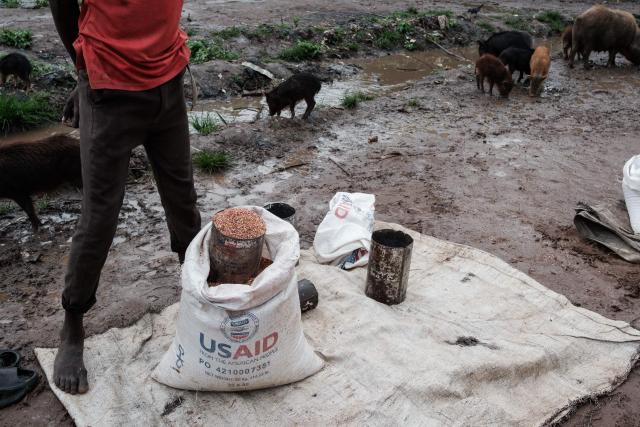(FILES) A man sells sorghum on the street from an old USAID bag and tin in Maban, South Sudan, on August 20, 2025. Hundreds of thousands displaced by conflict in South Sudan are increasingly forced to sell part of their rations to pay for basic needs at a time when the economy has almost entirely collapsed. One of the world's poorest countries, South Sudan has been mired in corruption and civil war for much of its existence since gaining independence in 2011. When US President Donald Trump ordered the shutdown of USAID last year, South Sudan lost a huge chunk of its humanitarian support at a time when nearly two-thirds of the population -- some 7.9 million people -- face acute hunger. (Photo by GUY PETERSON / AFP)