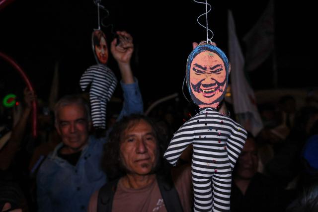 A supporter of Peru's presidential candidate for the Juntos por el Peru party, Roberto Sanchez, shows a doll depicting presidential candidate Keiko Fujimori as he waits for the start of his closing campaign rally in Lima on June 4, 2026. Right-wing candidate Keiko Fujimori and leftist Roberto Sanchez will face off in Peru's presidential runoff on June 7, 2026. (Photo by Connie FRANCE / AFP)