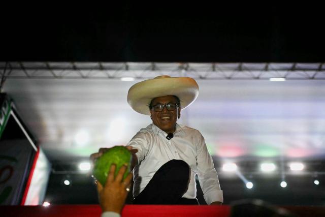 Peru's presidential candidate for the Juntos por el Peru party, Roberto Sanchez, receives a vegetable from a supporter during his closing campaign rally in Lima on June 4, 2026. Right-wing candidate Keiko Fujimori and leftist Roberto Sanchez will face off in Peru's presidential runoff on June 7, 2026. (Photo by ERNESTO BENAVIDES / AFP)