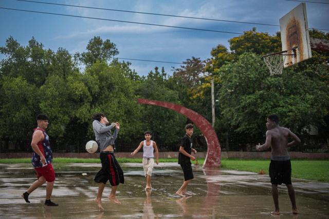 Teenagers play football on an abandoned basketball court in Havana on June 4, 2026. (Photo by AFP)