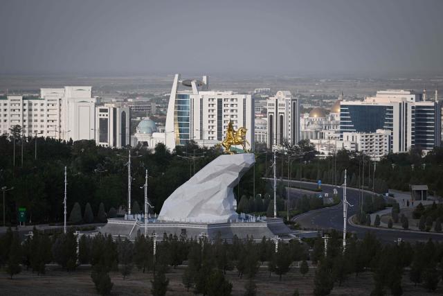 (FILES) A view shows the Golden Horse Monument featuring former Turkmen leader Gurbanguly Berdymukhamedov riding an Akhal-Teke, Turkmenistan’s national horse, in Turkmenistan's capital of Ashgabat on June 28, 2023. (Photo by Natalia KOLESNIKOVA / AFP)