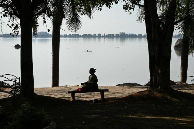 A woman meditates on the banks of Hussain Sagar Lake in Hyderabad on June 5, 2026. (Photo by Noah SEELAM / AFP)