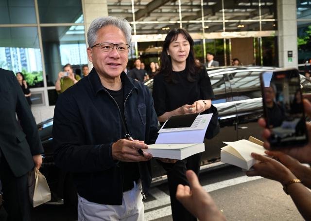 Nvidia CEO Jensen Huang gives his autographs to fans as he arrives at Gimpo airport in Seoul on June 5, 2026. (Photo by Jung Yeon-je / AFP)