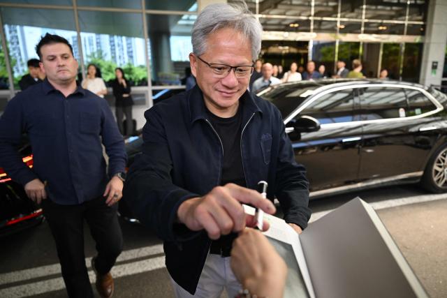 Nvidia CEO Jensen Huang gives his autographs to fans as he arrives at Gimpo airport in Seoul on June 5, 2026. (Photo by Jung Yeon-je / AFP)