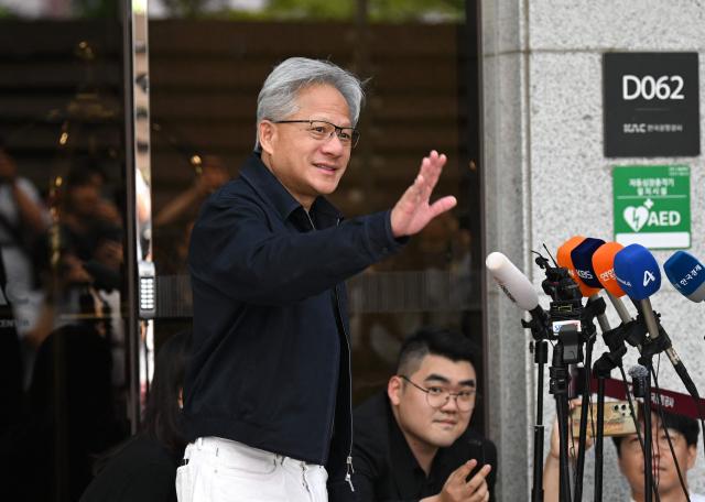 Nvidia CEO Jensen Huang waves to the media as he arrives at Gimpo airport in Seoul on June 5, 2026. (Photo by Jung Yeon-je / AFP)
