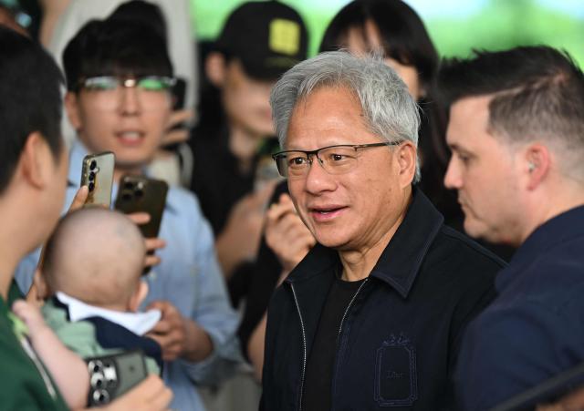 Nvidia CEO Jensen Huang gives his autographs to fans as he arrives at Gimpo airport in Seoul on June 5, 2026. (Photo by Jung Yeon-je / AFP)
