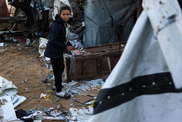 EDITORS NOTE: Graphic content / A Palestinian girl salvages items in the destroyed tents following an Israeli strike in Khan Yunis in the southern Gaza Strip on June 5, 2026. Despite a truce technically in effect since October 2025, daily violence has rocked the Gaza Strip, over half of which is under Israeli military control in defiance of the ceasefire's terms. Israel has killed at least 936 people since the ceasefire began, according to Gaza's health ministry, which operates under Hamas authority and whose figures are considered reliable by the UN. (Photo by BASHAR TALEB / AFP)