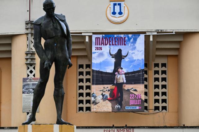 A poster is displayed at the entrance of the Plumacon bullring announcing the upcoming Madeleine festival in Mont-de-Marsan, southwestern France, on June 4, 2026. The poster, featuring the five-year-old daughter of former torero Thomas Dufau dressed as a bullfighter (torera), sparked controversy among anti-bullfighting groups — including a tribune signed by French singer Renaud, author Annie Ernaux and philisopher Elisabeth Badinter — who unsuccessfully sought its removal in court on June 1. (Photo by Gaizka IROZ / AFP)