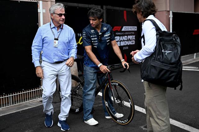 Williams' Spanish driver Carlos Sainz arrives on his bike, flanked by his father Carlos Sainz (L), ahead of the first practice session at the Monaco street circuit in Monaco, ahead of the Monaco Formula 1 Grand Prix, on June 5, 2026. (Photo by Gabriel BOUYS / AFP)