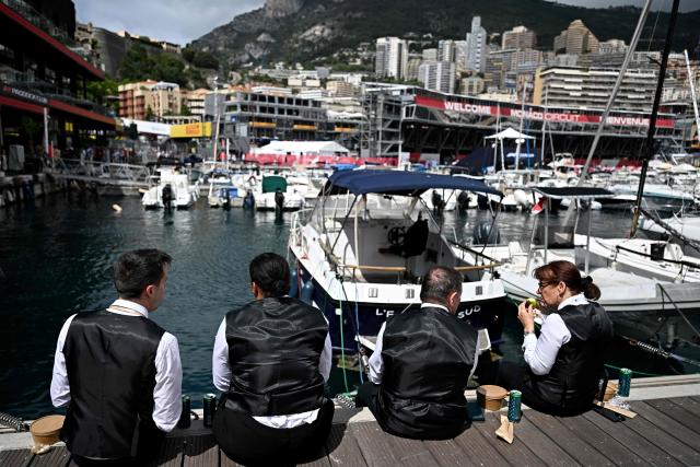 Waiters sit on a poontoon as they take a break in front of the Monaco street circuit in Monaco, ahead of the Monaco Formula 1 Grand Prix, on June 5, 2026. (Photo by Gabriel BOUYS / AFP)