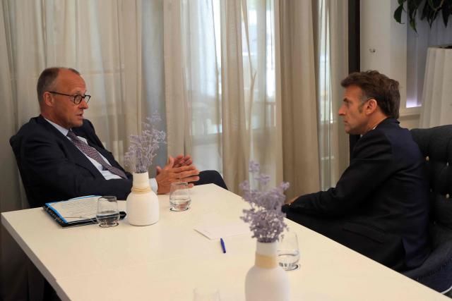 German Chancellor Friedrich Merz (L) and French President Emmanuel Macron speak with each other ahead of a meeting on the sidelines of the EU-Western Balkans Summit at Porto Montenegro in Tivat on June 5, 2026. (Photo by Ludovic MARIN / AFP)