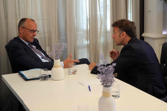 German Chancellor Friedrich Merz (L) and French President Emmanuel Macron speak with each other ahead of a meeting on the sidelines of the EU-Western Balkans Summit at Porto Montenegro in Tivat on June 5, 2026. (Photo by Ludovic MARIN / AFP)