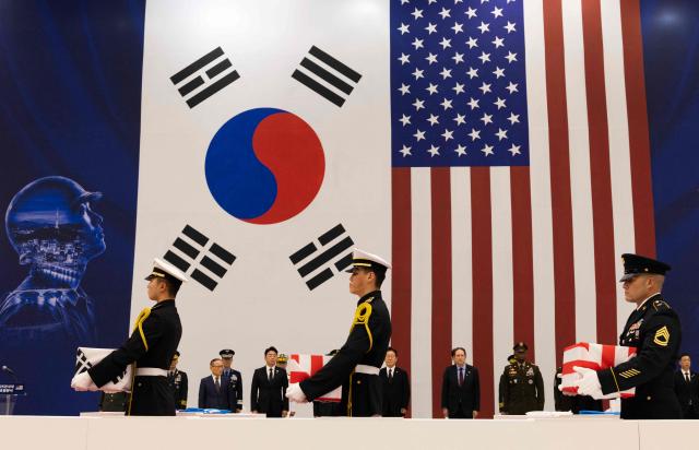 South Korean and US honour guards carry coffins containing the remains of soldiers killed in the 1950-53 Korean War during a repatriation ceremony at Seoul Military Air Base in Seongnam on June 5, 2026.  (Photo by JEON HEON-KYUN / POOL / AFP)