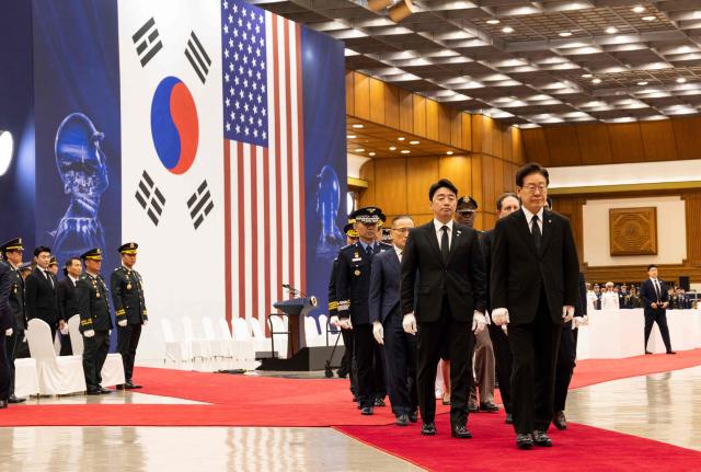South Korea's President Lee Jae Myung (R) walks during a repatriation ceremony for the remains of soldiers killed in the 1950-53 Korean War at Seoul Military Air Base in Seongnam on June 5, 2026.  (Photo by JEON HEON-KYUN / POOL / AFP)